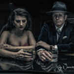 Film noir couple drinking at dimly lit bar