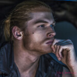Pensive blond man resting chin on hand