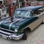 Vintage green two-tone station wagon at gas station