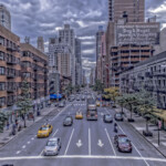Busy city street with taxis and cloudy sky
